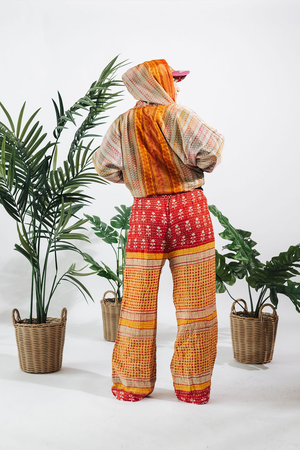 a person in a colorful outfit standing next to plants