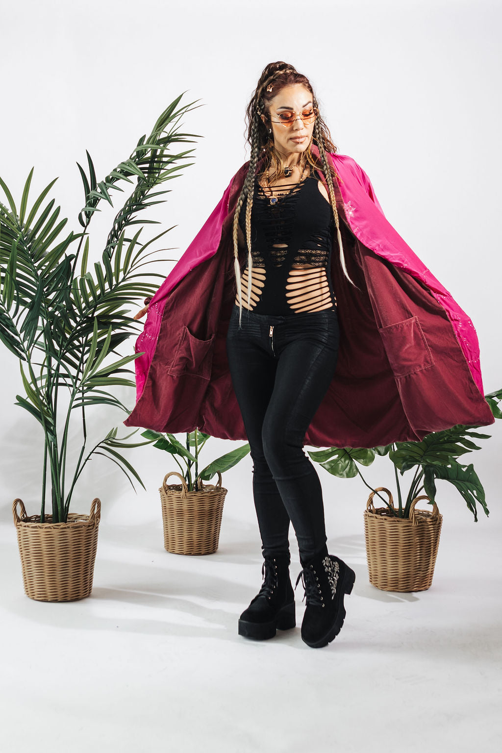 a woman wearing a pink coat and black pants