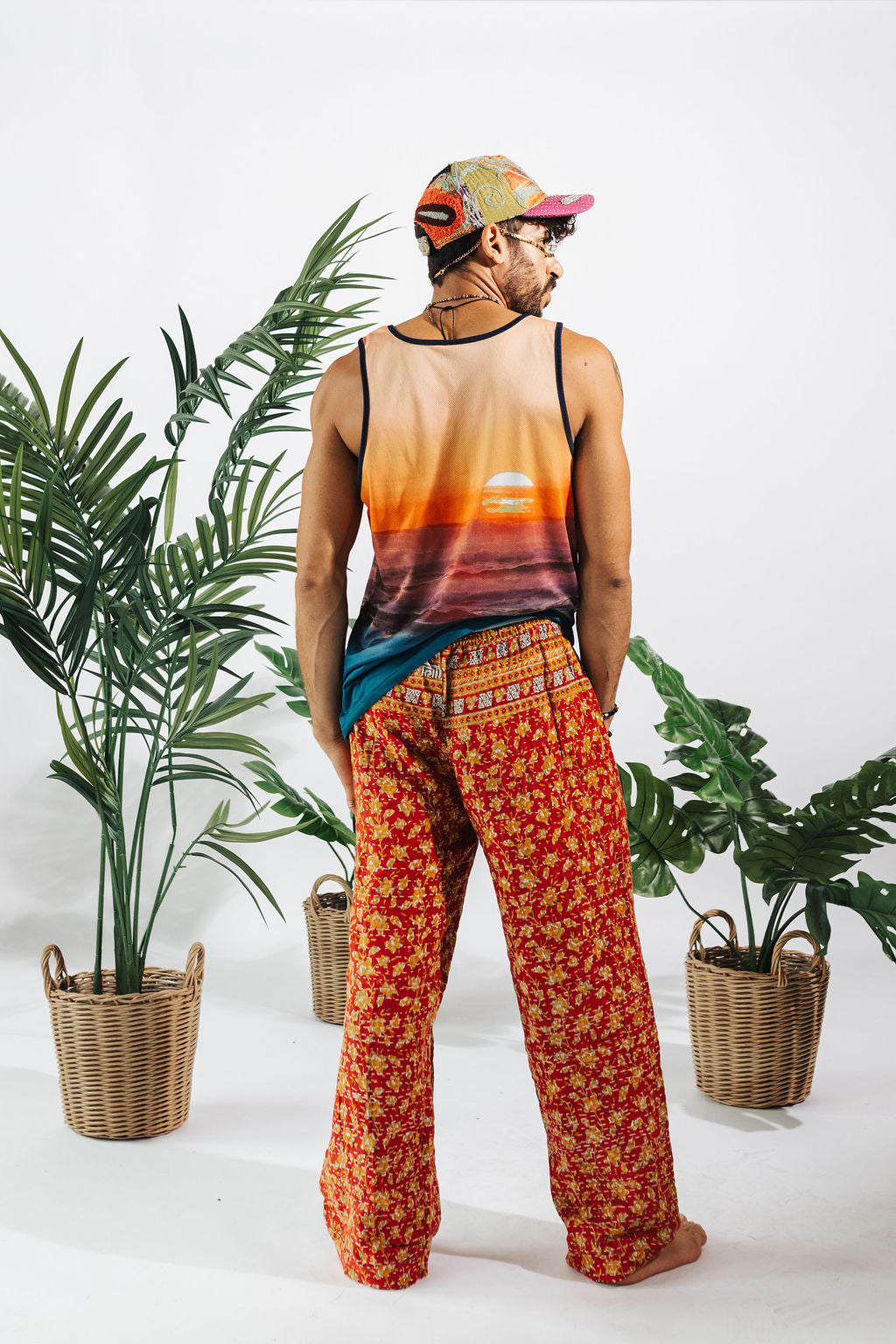 a man in a tank top and colorful pants
