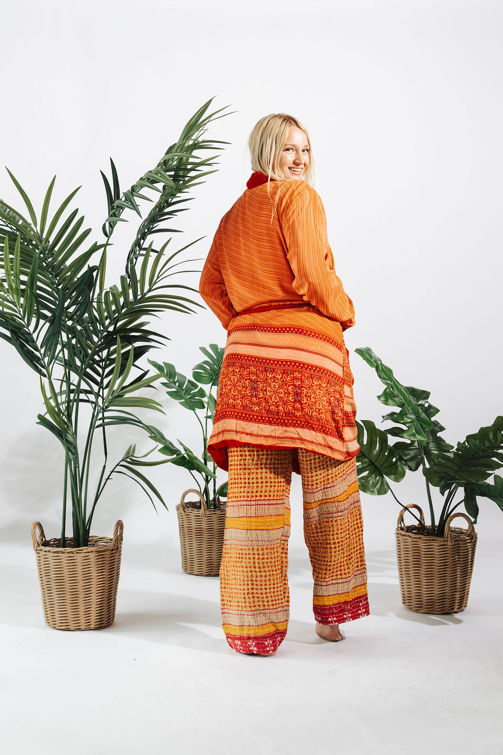a woman standing in front of two baskets of plants
