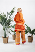a woman standing in front of two baskets of plants