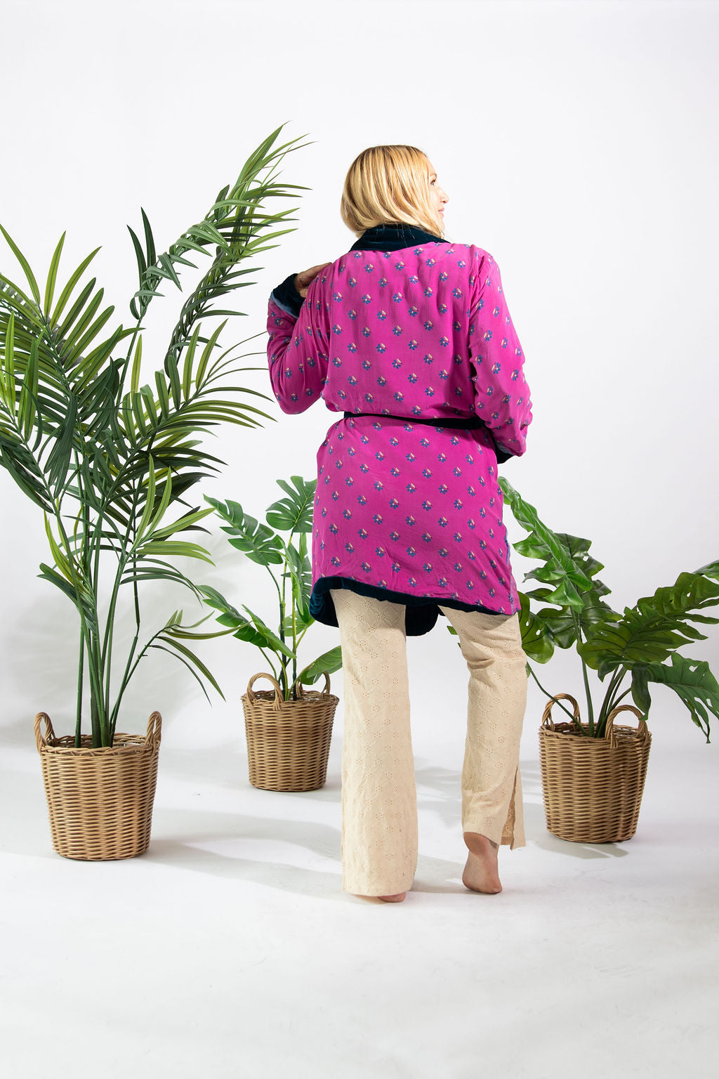 a woman standing next to a plant